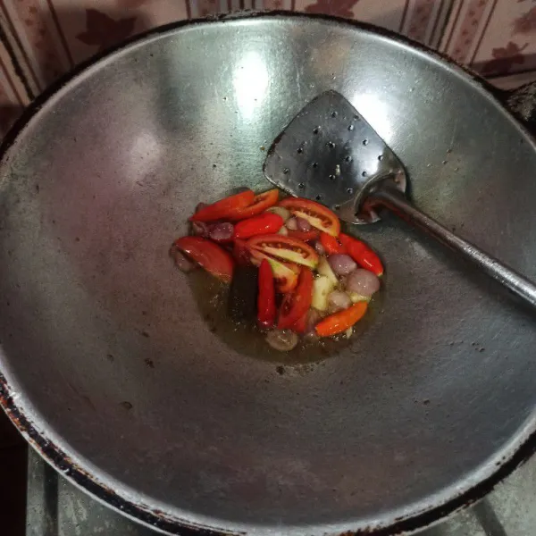 Goreng bawang merah dan bawang putih sampai layu, setelah itu masukkan cabai merah, terasi dan tomat, goreng hingga matang.
