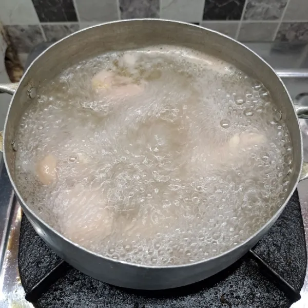 Rebus air secukupnya sampai mendidih. Masukkan ayam, rebus sampai keluar minyaknya dengan api kecil sedang. Buang busanya saja, lalu matikan kompor. Sisihkan.