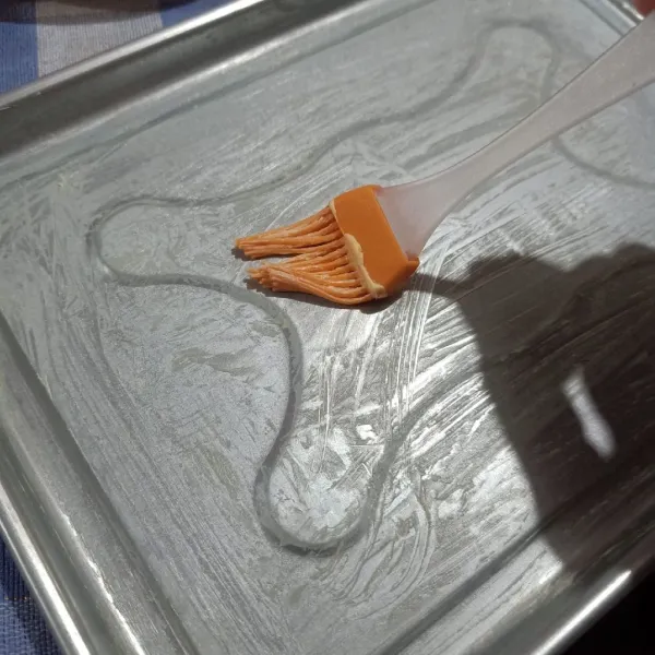 Oles loyang dengan margarin.