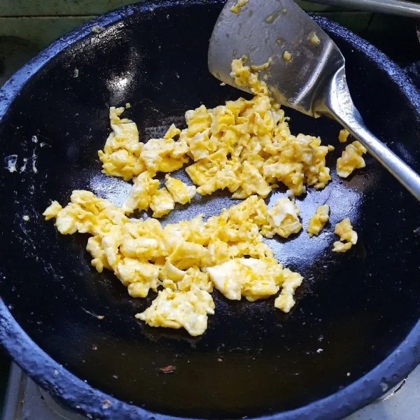 Orak-arik telur di atas wajan sampai matang.