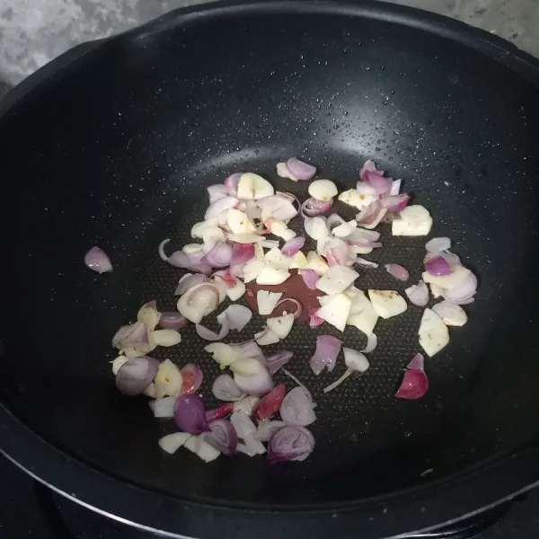Tumis irisan bawang merah dan bawang putih sampai harum.