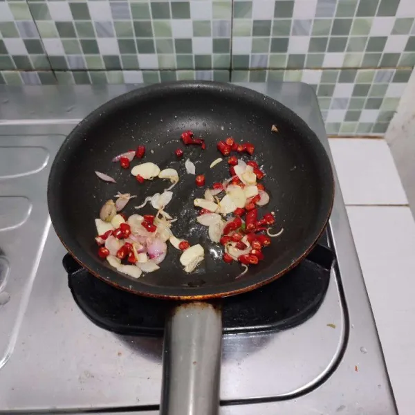 Kemudian masukkan cabe merah dan cabe rawit, tumis hingga layu.