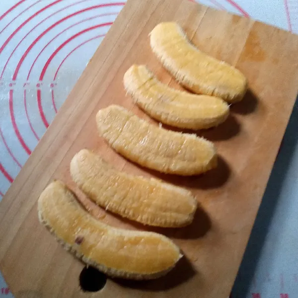 Kupas pisang dan tekan sedikit dengan spatula agar lebih pipih.