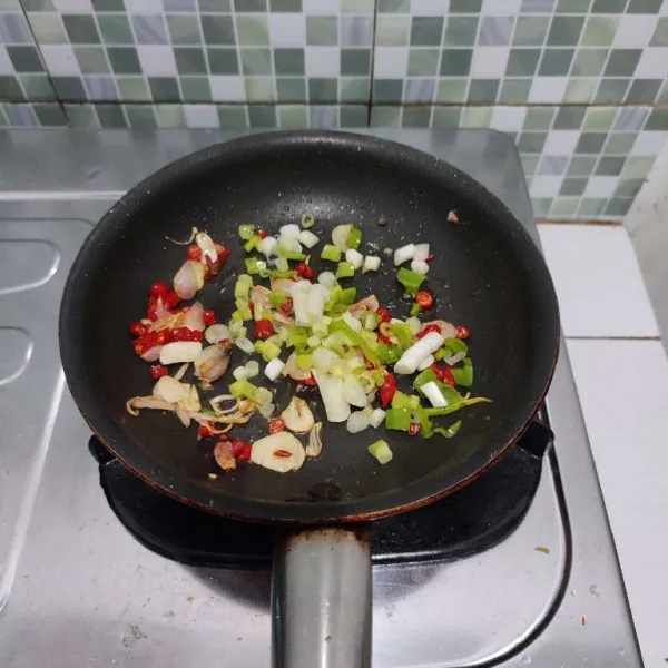 Masukkan daun bawang, tumis hingga layu.