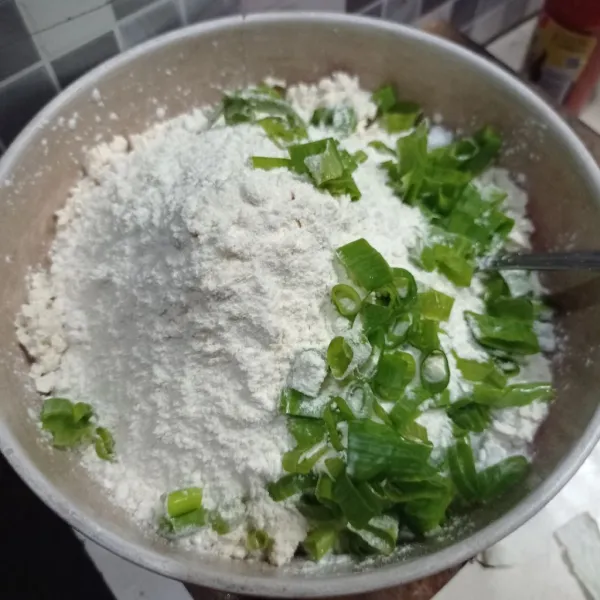 Lalu tambahkan tepung terigu, tepung tapioka, irisan daun bawang, garam, dan kaldu bubuk.