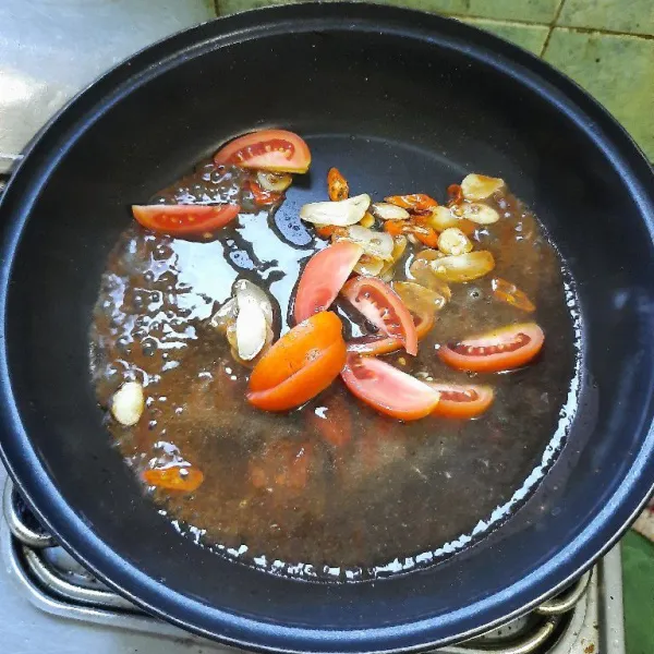 Tumis bawang putih sampai layu, masukkan bumbu dan tomat, aduk-aduk.