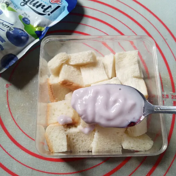 Siapkan box, tata setengah bagian roti tawar di dasar box. Timpa dengan yogurt cream, ratakan dan rapikan.