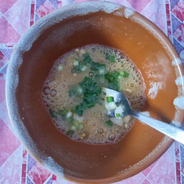 Kocok lepas telur, kemudian beri irisan daun bawang, aduk rata.