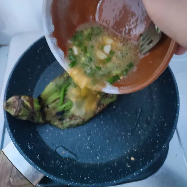 Panaskan kembali teflon, letakkan terong di atas teflon, kemudian siram dengan kocokan telur. Goreng hingga matang. Sajikan selagi hangat, bisa disajikan dengan sambal.