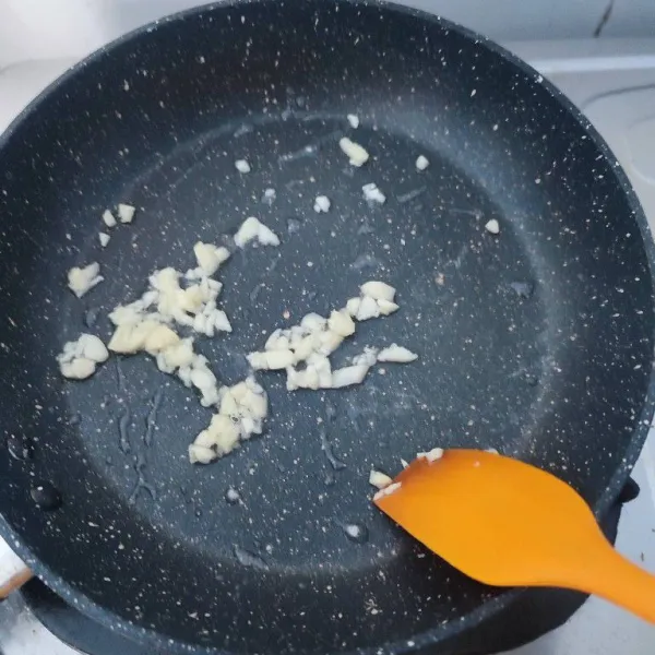 Tumis bawang putih cincang hingga harum dan agak kecoklatan.