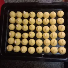 Siapkan loyang yang telah diolesi margarin, ambil adonan kulit nastar seberat 6 gram kemudian pipihkan isi bagian dalamnya dengan selai nastar, bulatkan adonan dan beri hiasan potongan almond slice, panggang selama 20 menit.