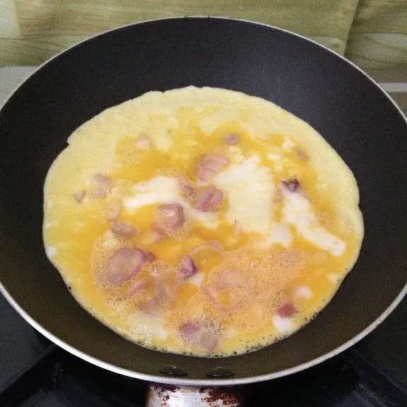 Goreng telur dadar hingga semua sisi matang lalu angkat. Tata nasi, telur dadar bawang merah, dan sambal bawang di piring lalu sajikan.