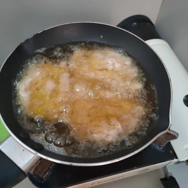 Panaskan minyak goreng, masukkan adonan bentuk pipih, goreng hingga setengah kering.