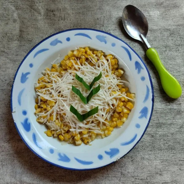 Tambahkan keju parut lagi di atas jagung dan sajikan hangat.