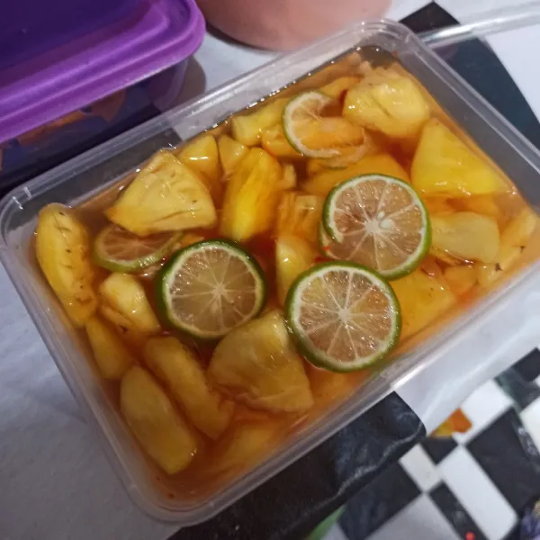 Tuang ke nanas, lalu beri air jeruk nipis dan sebagian jeruknya di iris.