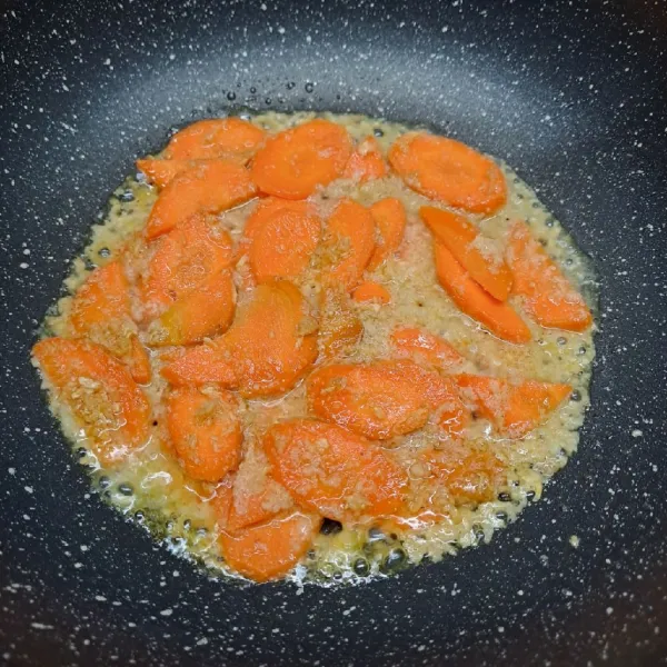 Masukkan wortel dan sedikit air, masak sampai ½ matang.