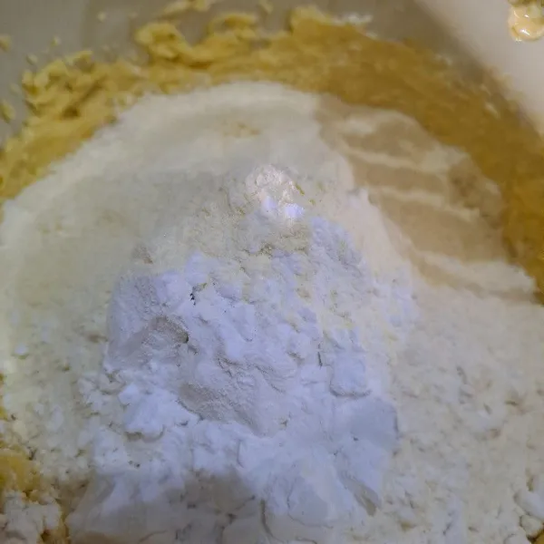 Masukkan tepung terigu dan susu bubuk, lalu aduk dengan sendok kayu hingga tercampur rata.