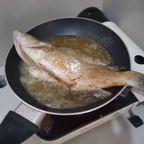 Sisit bagian daging ikan, marinasi dengan bubuk bumbu ikan goreng, kemudian goreng hingga garing.