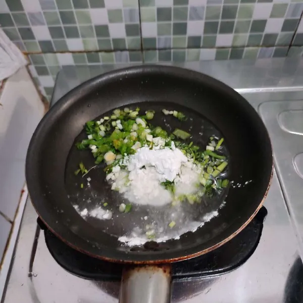 Campurkan air, daun bawnag serta tepung tapioka ke dalam wajan. Aduk rata.