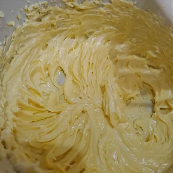 Kocok butter (mentega), margarin, gula halus, dan kuning telur sebentar saja asal rata.