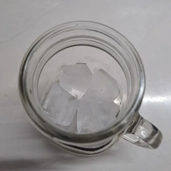 Ambil gelas saji, beri es batu secukupnya.