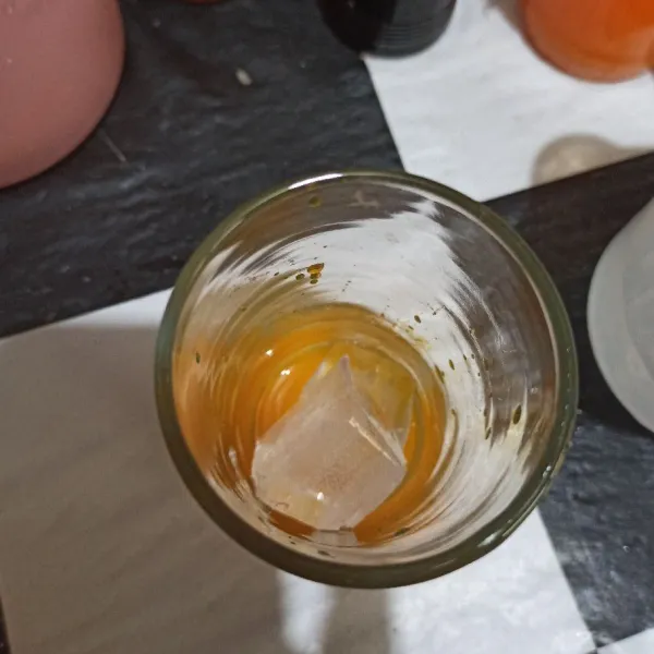 Masukkan es batu ke gelas.