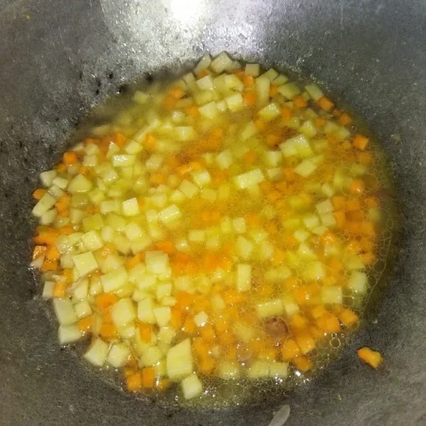 Tumis bawang merah dan bawang putih hingga harum, lalu masukkan wortel, kentang dan air, masak hingga airnya menyusut dan wortel empuk.