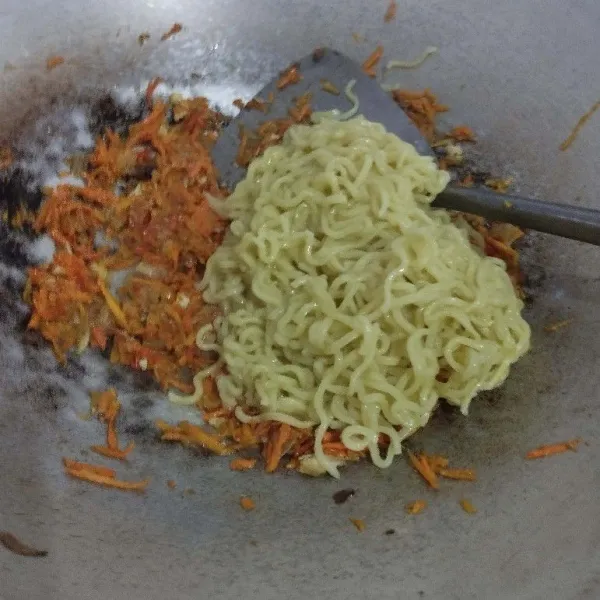 Masukkan mie yang sudah direbus tadi. Aduk rata. Tambahkan daun bawang.