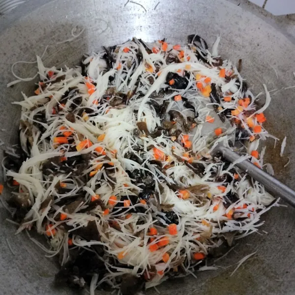 Masukkan wortel, aduk rata lalu masukkan jamur hitam, telur, dan bihun. Tambahkan gula, garam, pala, merica, dan kaldu jamur. Tes rasa dan sisihkan.