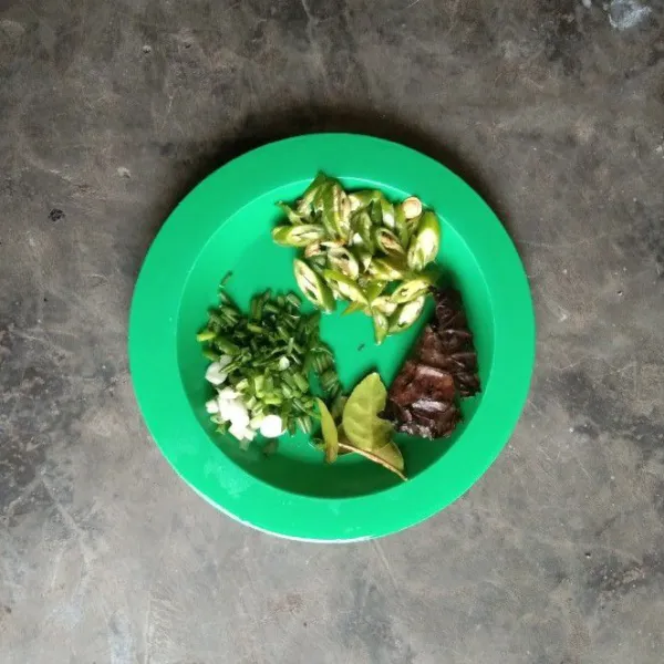 Siapkan daun salam dan daun jeruk. Iris serong cabe hijau. Iris tipis daun bawang.
