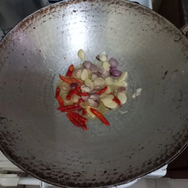 Goreng irisan bawang putih, bawang merah, dan cabai merah keriting hingga harum.