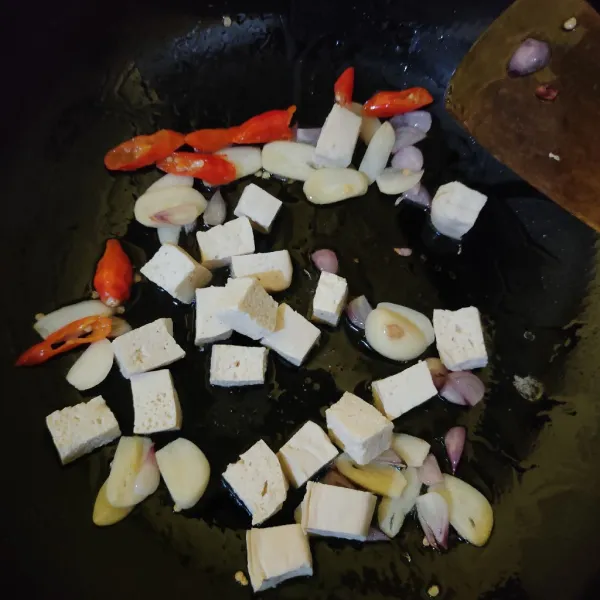 Masukkan tahu, aduk rata.