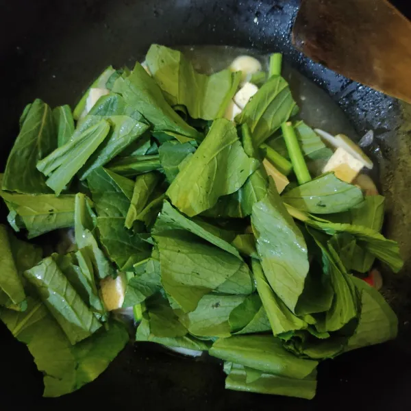 Masukkan daun sawi, aduk rata.