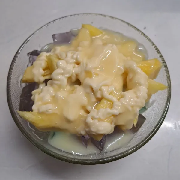 Beri mayonaise dan krimer kental manis. Aduk sampai rata. Taburi keju cheddar parut. Sajikan.