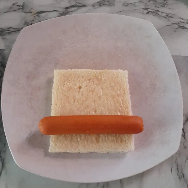 Letakkan sosis di ujung roti tawar.