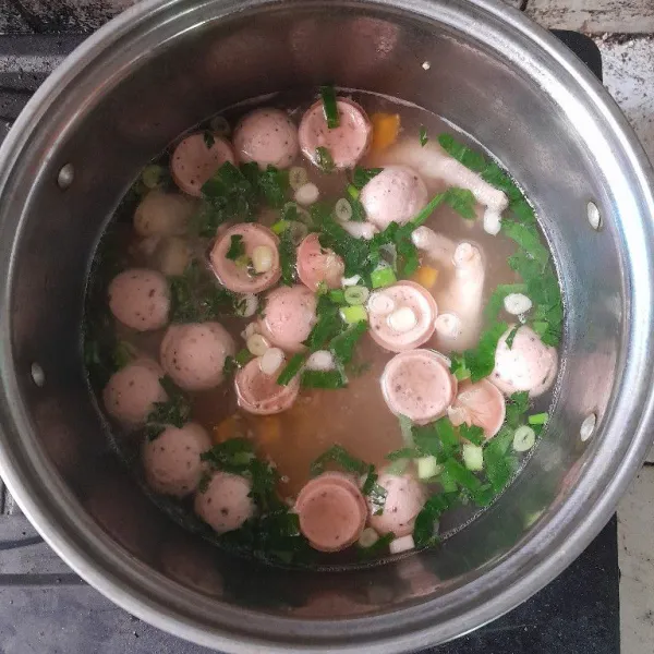 Masak sebentar hingga sosis matang, tambahkan irisan daun bawang dan seledri, sajikan hangat.