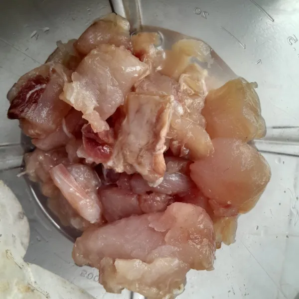 Siapkan blender, masukkan potongan daging ikan tenggiri, bawang putih dan air es. Blender hingga halus.