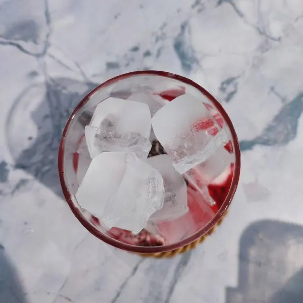 Tambahkan es batu sampai ¾ tinggi gelas.