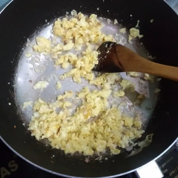 Panaskan minyak lalu scrambel telur, angkat, kemudian tumis bawang merah dan bawang putih hingga harum, masukkan telur scrambel irisan wortel, kubis, bakso, sosis, tumis, tambahkan air