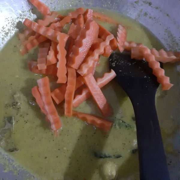 Masukkan wortel, aduk rata dan masak hingga setengah matang.