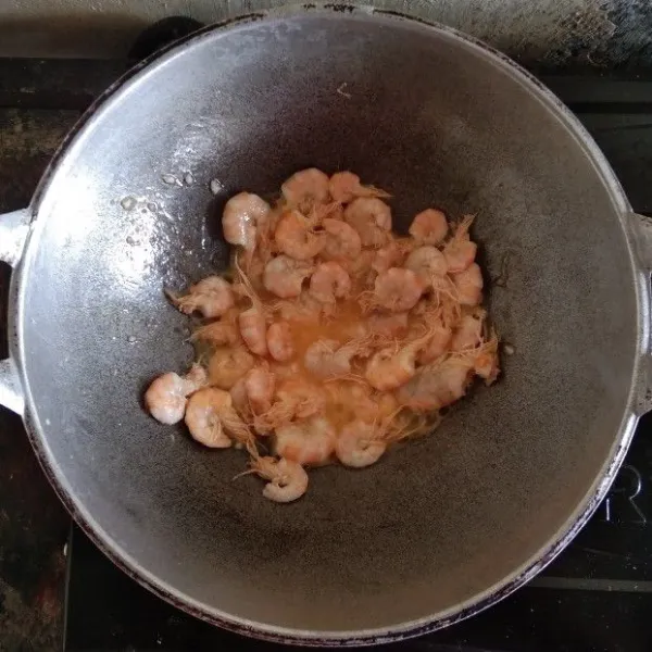 Tumis udang dengan minyak hingga berubah warna dan setengah matang.