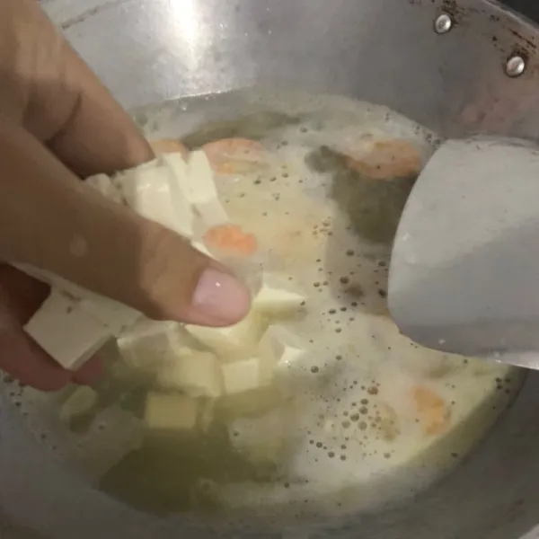 Potong kecil tahu dan masukkan.