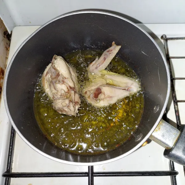 Cuci bersih ayam, lalu rebus dan goreng sebentar.