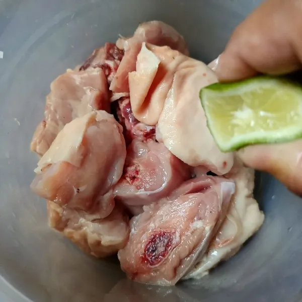 Kucuri ayam dengan jeruk nipis dan diamkan sebentar, lalu cuci bersih.