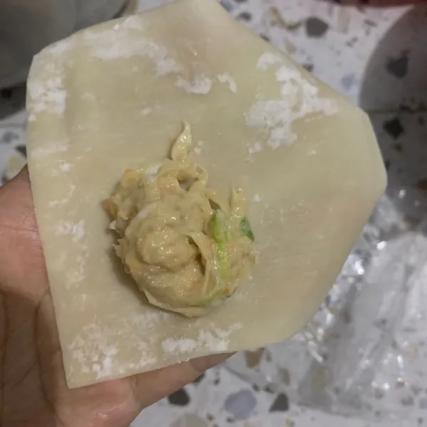 Taroh adonan pentol di ujung kulit pangsit.