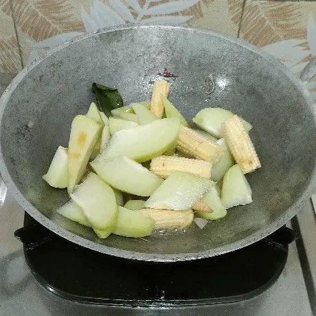 Masukkan jagung muda dan manisan, tumis sampai layu.
