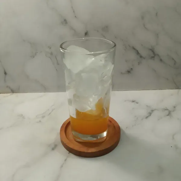 Siapkan gelas. Tuang sirup jeruk dan es batu secukupnya.