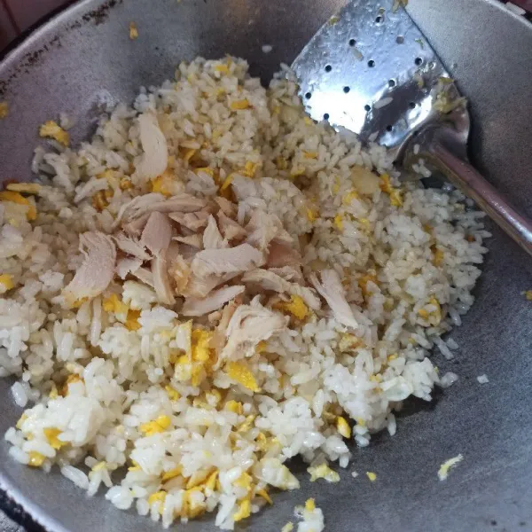 Masukkan nasi dan ayam suwir, aduk rata dan masak dengan api besar.