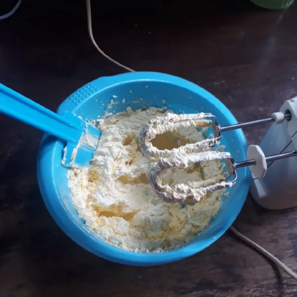 Mixer butter dan gula halus dengan kecepatan tinggi selama 2 menit.