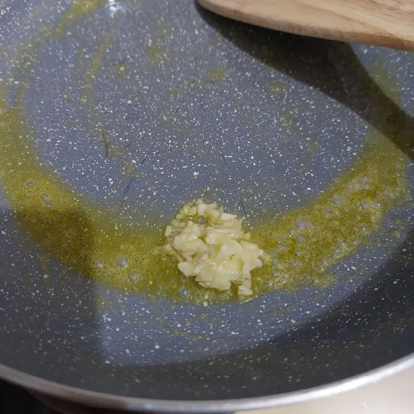 Panaskan margarin di teflon. Masukkan setengah bawang putih yang sudah dicincang.